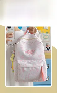 Detail of pink marble pattern backpack with plush heart charms and adjustable straps