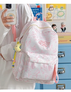 Detail of waterproof marble print backpack with plush moon charm in school setting