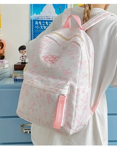 Detail of pink marble backpack featuring a zip pocket and branded ribbon for students