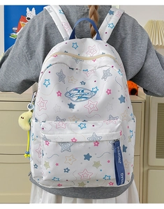 Close-up of waterproof star pattern backpack with navy blue straps and moon plush charm