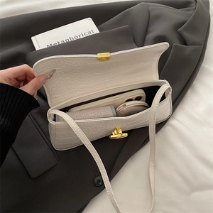 White crocodile pattern shoulder bag with gold twist lock showing interior storage capacity