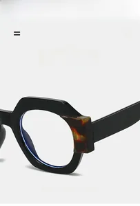 Detailed close-up of thick black polygon frame with amber tortoiseshell hinge accents