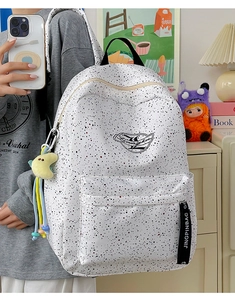 Detail of waterproof polka dot backpack with plush moon pendant and logo webbing