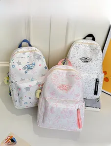 Detailed view of three waterproof canvas backpacks with star, camouflage and polka dot prints