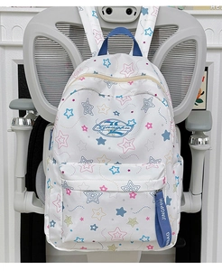Detail of white backpack with colorful star patterns and a blue decorative strap detail