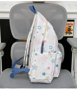 Close-up of white star print backpack with blue side pocket on an office chair