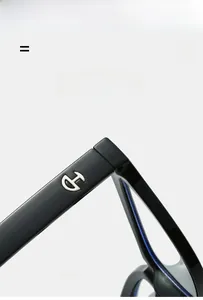 Détail de lunettes noires légères et super élastiques avec logo en métal sur charnière