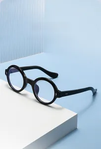 Close-up of retro round black frame sunglasses with blue polarized lenses and metal rivets
