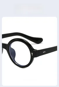 Close-up of retro round black sunglasses frame with silver metal rivets and sleek finish