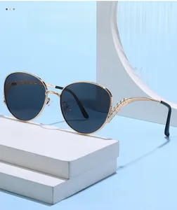Détail des branches en métal doré ajouré sur des lunettes de soleil oversize ornées