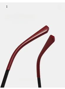Detail of ergonomic curved eyewear temples in matte black metal and dark red tips