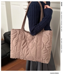 Quilted padded tote bag showing large capacity and wavy stitching detail on a shoulder strap