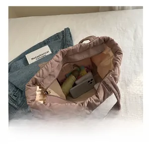 Spacious interior of lotus pink quilted nylon tote bag with zipper closure and essentials