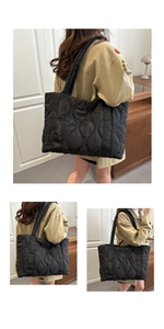 Detail of black quilted tote bag with wave texture and spacious interior design