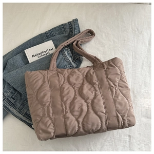 Detail of taupe quilted tote bag with wave stitching and soft padded carry handles