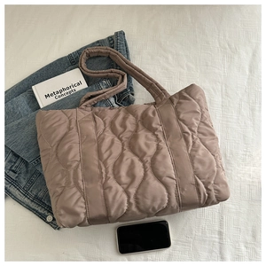 Close-up of wave-quilted puffer tote bag in Morandi color palette on white fabric