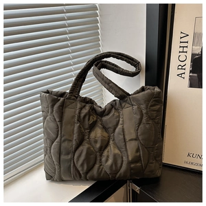 Detail of olive green quilted tote bag with wave stitching and soft downy material