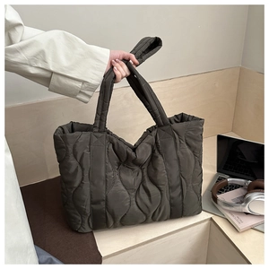 Detail of wave-quilted tote bag in olive green showing padded handle and nylon texture