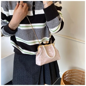 Détail du sac bandoulière en jacquard rose avec grand fermoir perle et chaîne dorée