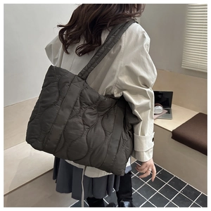 Detail of dark quilted tote bag showing wave-pattern stitching and durable nylon texture