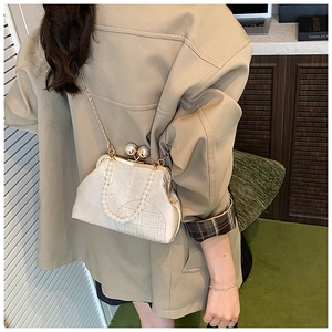 Détail d'un sac jacquard crème élégant avec anse en perles et fermoir métallique