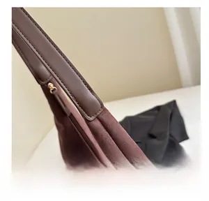 Close-up of suede texture and reinforced stitching on a coffee brown tote bag