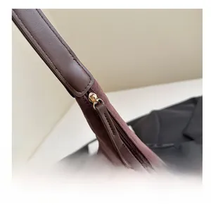 Detail of smooth metal zipper and suede texture on dark brown retro tote bag