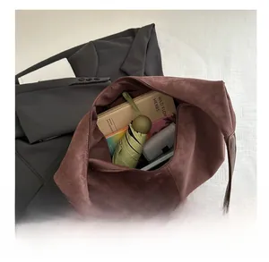 Spacious interior of brown suede tote bag showing storage for books and umbrella