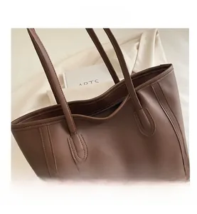 Close-up of litchi grain brown leather tote bag showing reinforced stitching and wide opening