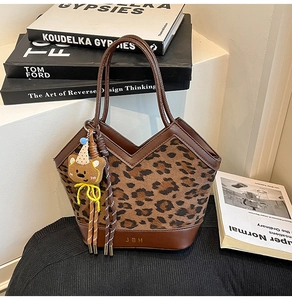 Detail of leopard print tote with brown leather trim and cute plush bear charm