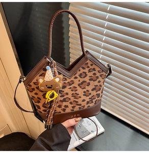 Detail of leopard print bucket bag with JH logo and cute bear charm in stylish setting