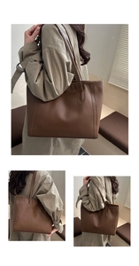 Detailed close-up of textured caramel leather tote bag with reinforced shoulder straps