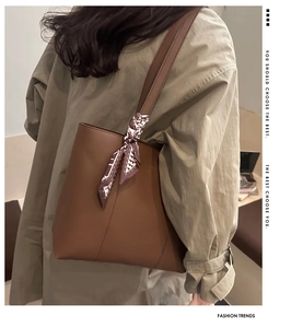 Dettaglio borsa tote in pelle marrone vintage con foulard in seta sulla tracolla