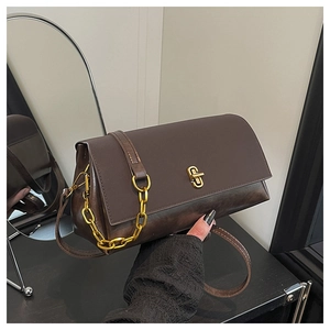Detail of vintage dark brown faux leather shoulder bag with golden interlocking clasp