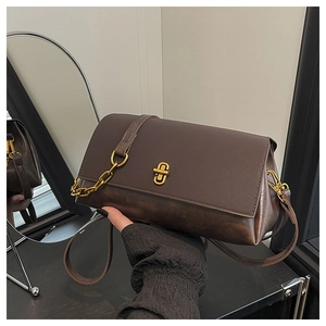 Detail of dark brown vintage handbag featuring a gold rotary lock and mixed leather textures