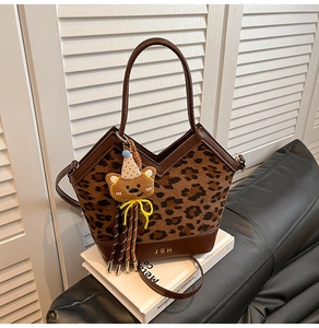 Detail of leopard print handbag with brown PU leather, V-shaped opening and bear charm