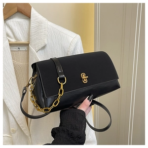 Detail of black leather handbag with gold twist lock and elegant decorative chain strap