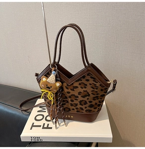 Detail of leopard print bucket bag with V-shaped opening and cute bear charm