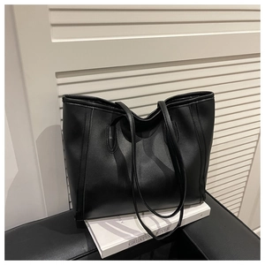 Close-up of minimalist black matte tote bag with large capacity and smooth leather texture
