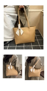 Detail of khaki tote bag with elegant silk scarf accent and logo print texture
