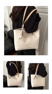 Detail of a chic cream leather tote bag with silk scarf and brown shoulder straps
