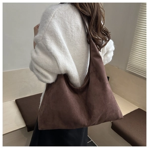Detail of a large dark brown suede tote bag showing its soft texture and slouchy shape