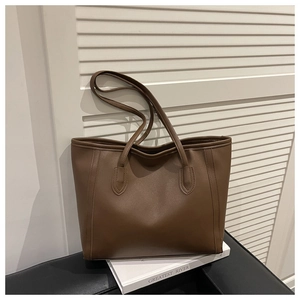 Detail view of large brown leather tote bag with reinforced stitching and long straps