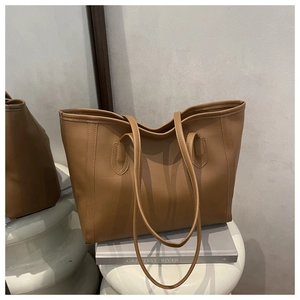 Detail of classic brown tote bag with decorative stitching and smooth faux leather finish