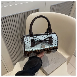 Detail of sweet cylindrical handbag with bow, heart pendant, lace trim and star patterns