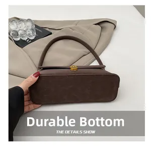 Dettaglio della base resistente della borsa in pelle opaca marrone con fibbia oro