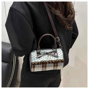 Detail of blue star pattern bag with brown bow, lace edges and metal heart charm