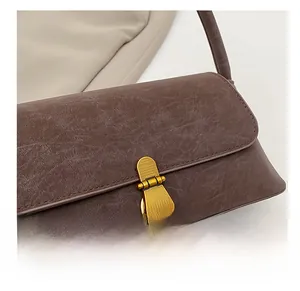 Dettaglio della borsa in pelle marrone vintage con fibbia metallica e finitura ruvida