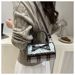 Détails du sac cylindre vintage avec imprimé étoiles, carreaux et nœud marron
