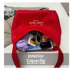 Top view of red tote bag showing large capacity with umbrella, sunglasses and books inside